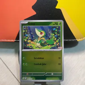 Kartu yang ditampilkan adalah kartu Pokémon Trading Card Game (TCG) dari Pokémon Snivy.