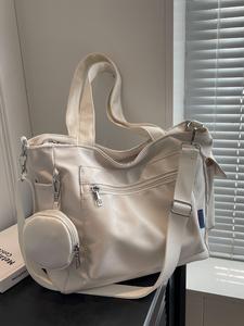 カジュアルでスタイリッシュな大容量の、滑らかなファスナー仕様のトートバッグ。ハンドやショルダー、クロスボディに対応する多用途タイプで、コインケース付き。