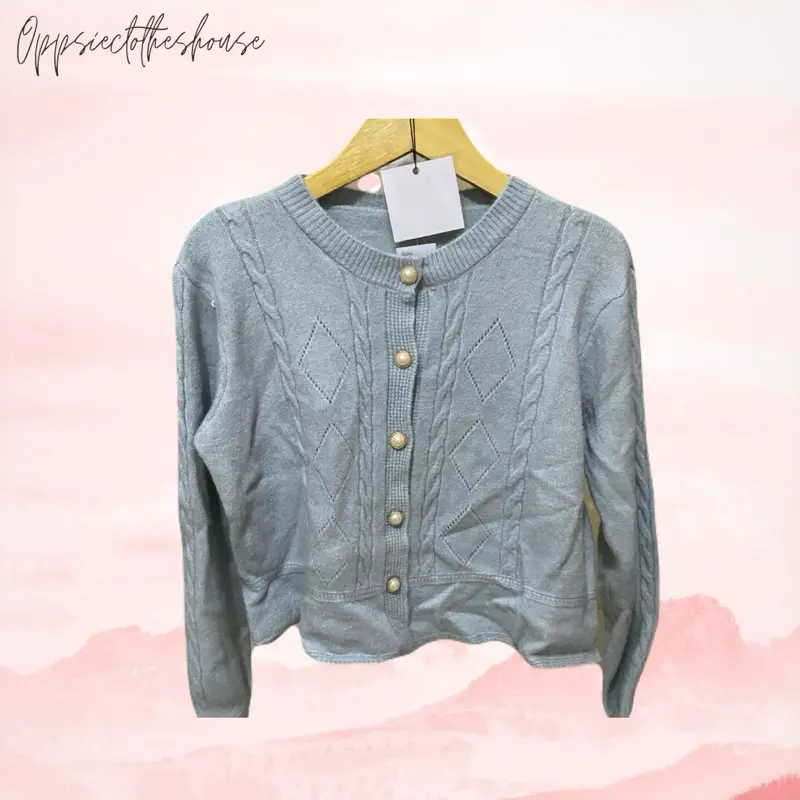 cardigan rajut wanita bermodel kerah polo kancing penuh dengan aksen saku kecil di bagian dada kiri berwarna mint green atau hijau muda pastel yang lembut.