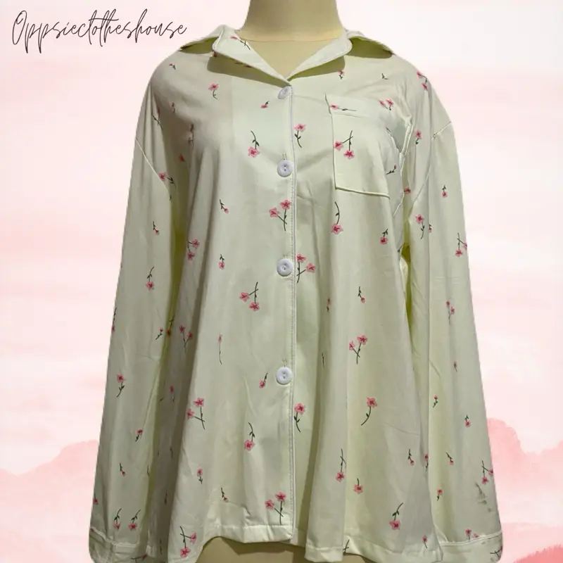 piyama wanita (pajama top) bermotif floral atau bunga kecil berwarna merah muda dengan warna dasar krem/putih tulang.