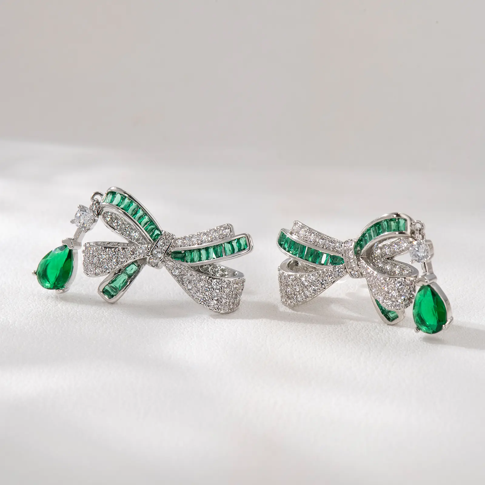 Elegant Bow Earrings with Green Gemstones and Sparkling Diamonds - Platinum Plated, Perfect for Special Occasions