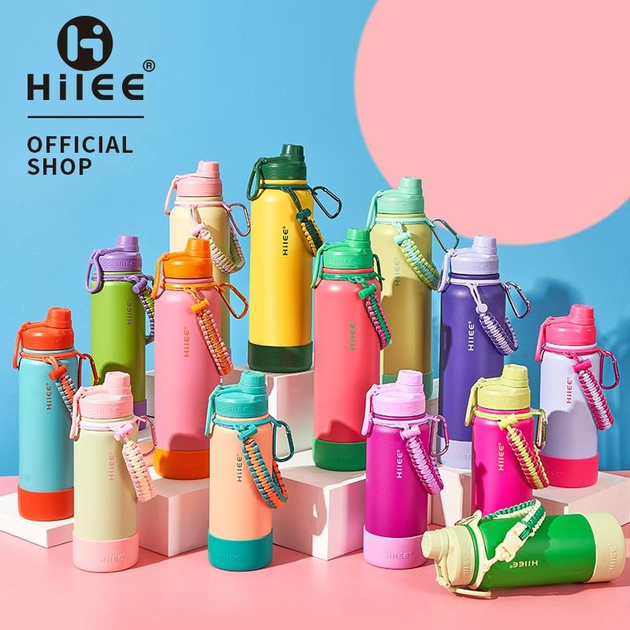 Hilee Versão Frutas – Garrafa Térmica com Aço Inoxidável de Grau Cirúrgico · Brinde: Base de Silicone + Alça Trançada · Estampa Frutal Fofa e Portátil