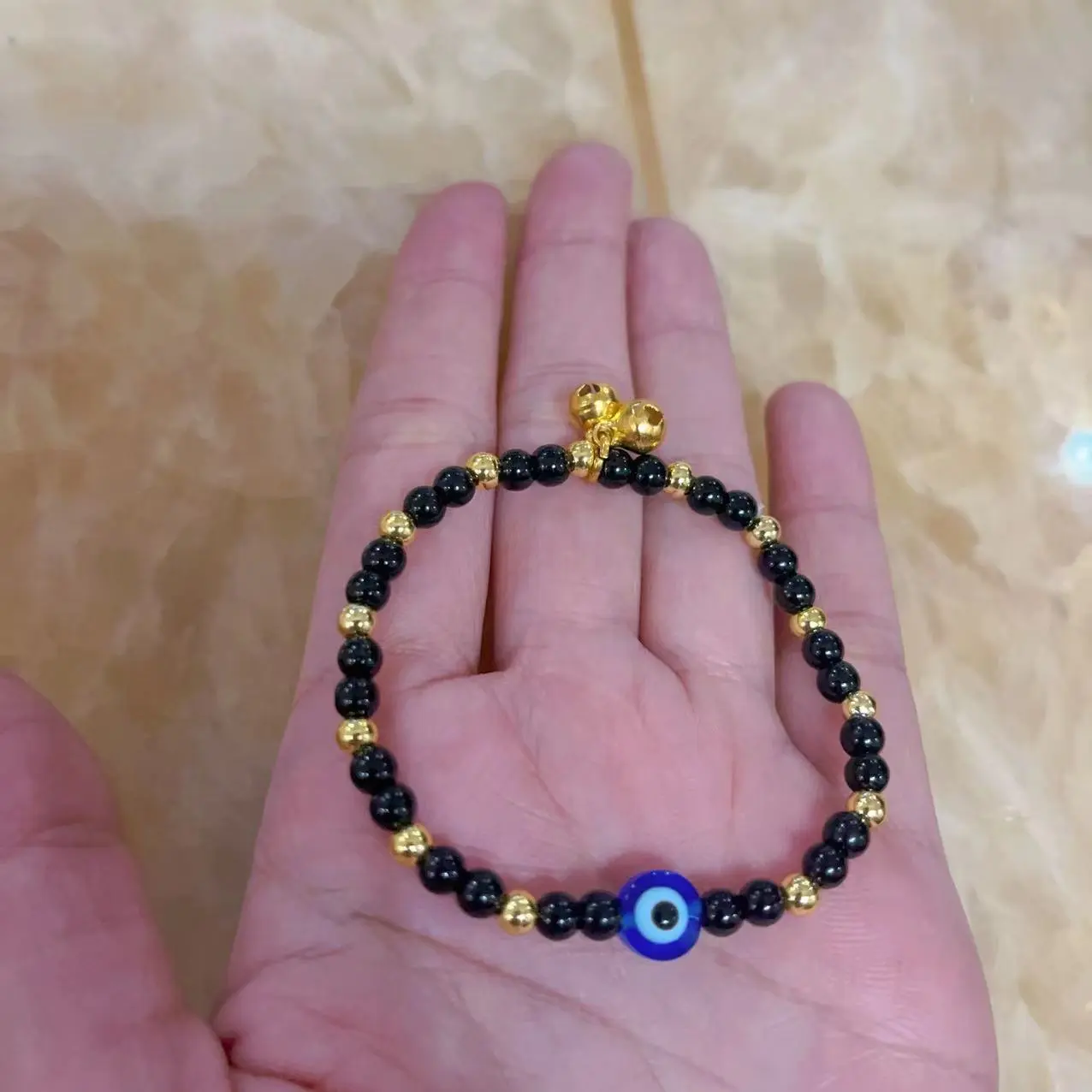 evil eye bracelet with gold beads and bells