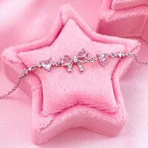 Vòng tay đính đá màu hồng với họa tiết nơ và trái tim