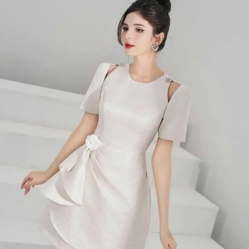 Váy vai cut out tà xếp ly cài hoa màu kem