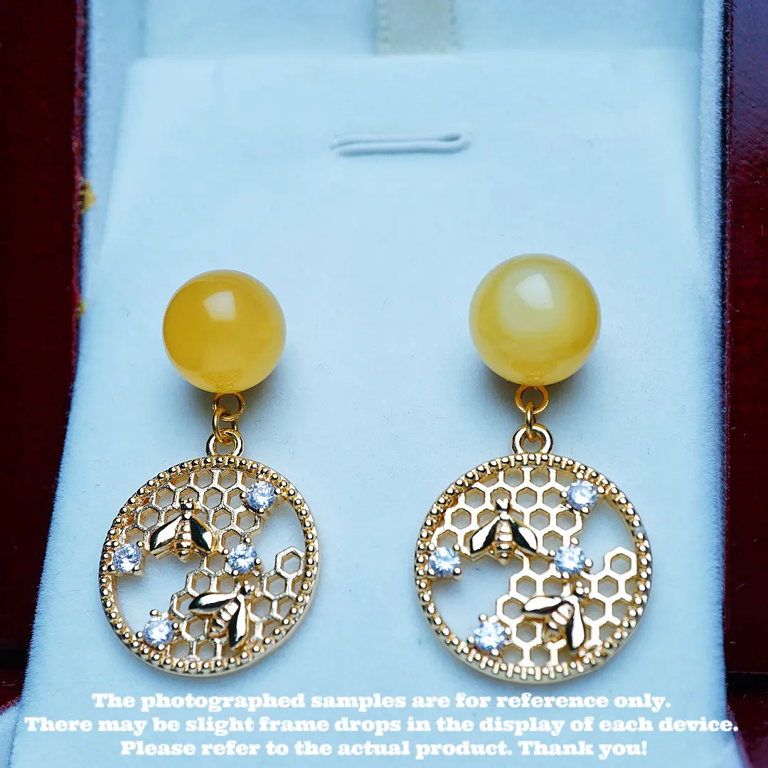 These are a pair of ear pendants made of natural raw ore amber and beeswax.