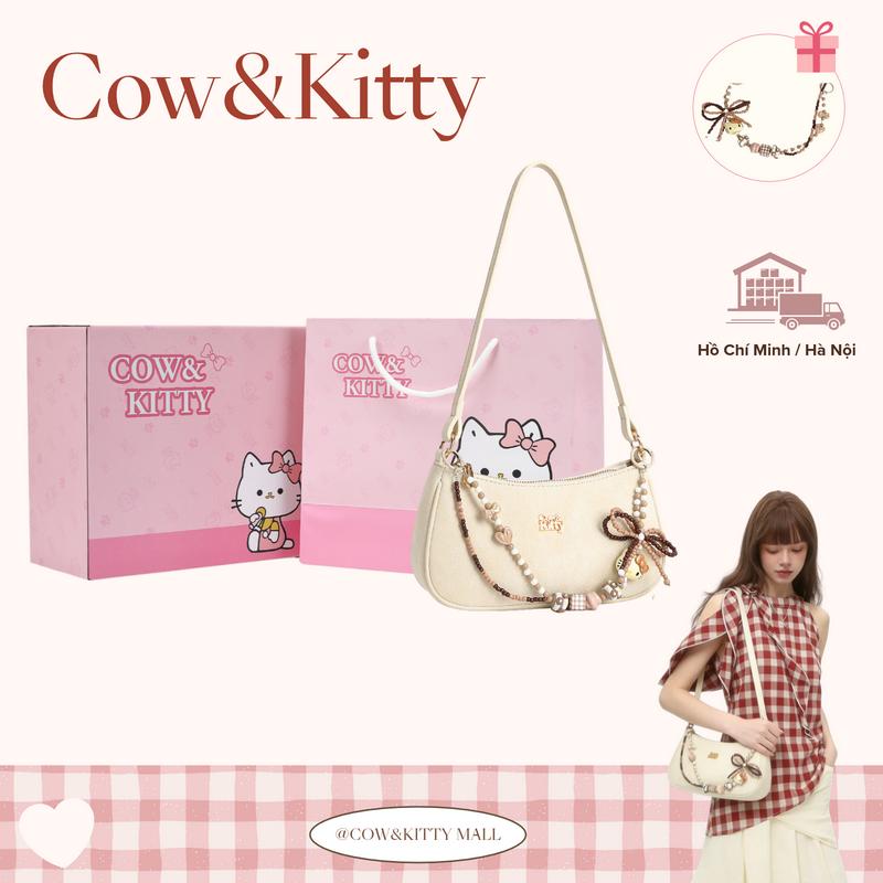 Bao gồm một món phụ kiện hình mèo con tặng kèm!Cow&Kitty-Chiếc túi xách màu trắng ngà mới này có thể đeo vai hoặc đeo chéo. Túi đi kèm với dây đeo vai và một chiếc charm đính hạt miễn phí.