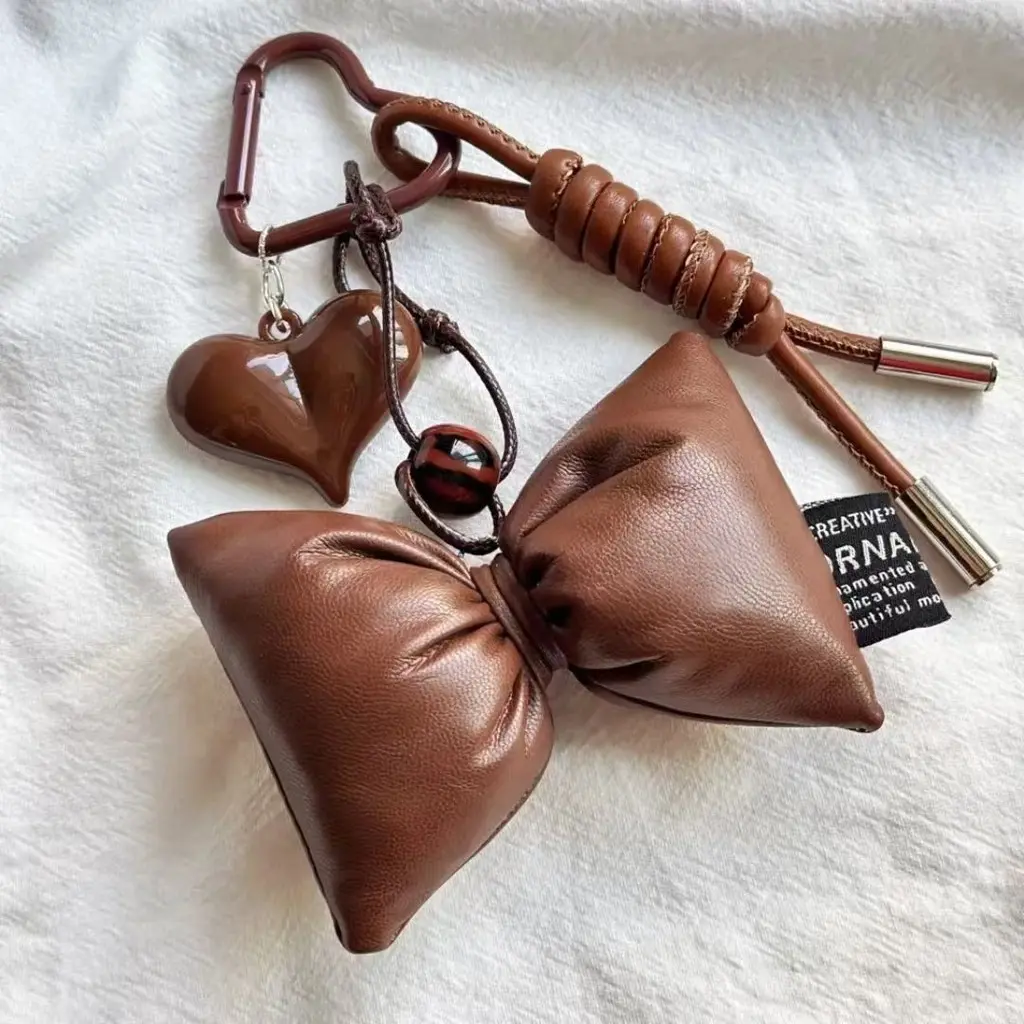 Gantungan untuk tas kulit berwarna coklat.
