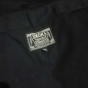 SMOKE Syndicate Overall Reguler Fit Service Suit Pria Panjang Hitam Bahan Ripstok Tahan Lama 1 Kantung Depan 1 Kantung Belakang 2 Kantung Sisi