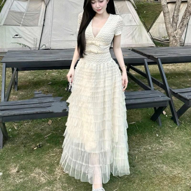 Váy thiết kế ren tay cọc cổ V đính nơ chân lưới tầng dáng dài NQa39