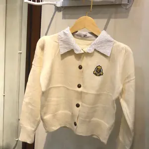 Switter Rajut Wanita Kerah Warna Putih Import BKK dengan Detail Logo Elegan dan Kancing Depan