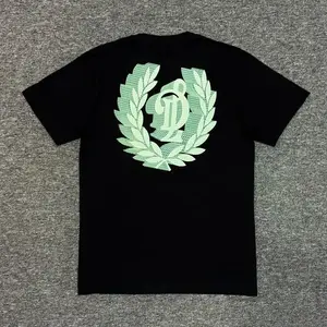 Kaos Hitam dengan Cetakan Laurel & Monogram Hijau Muda Stylish – Desain Elegan dengan Detil Grafis Keren, Bahan Nyaman Sehari-hari, Versi Putih Jugakilzfutsy