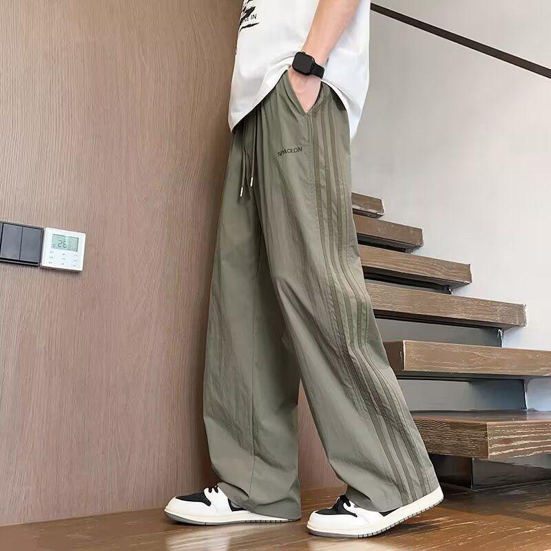 Quần dài nam ống rộng dáng suông lưng thun dây rút chất vải mỏng nhẹ rũ mềm thêu chữ phong cách casual streetwear quần thể thao thời trang mặc hằng ngày thoải mái dễ phối đồ size lớn